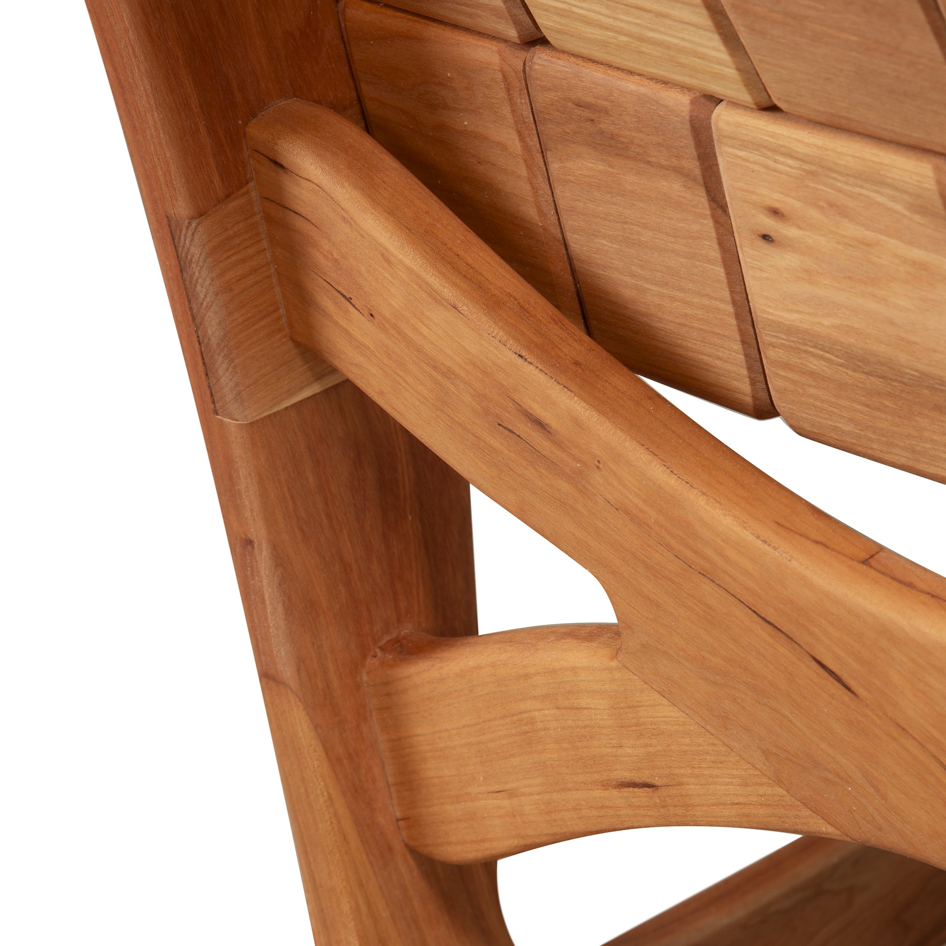 Close-up of Vermont Folk Rocker’s Special Order Quilted Rocking Chair, showcasing unique angled joints and rich, smooth wood grain craftsmanship.