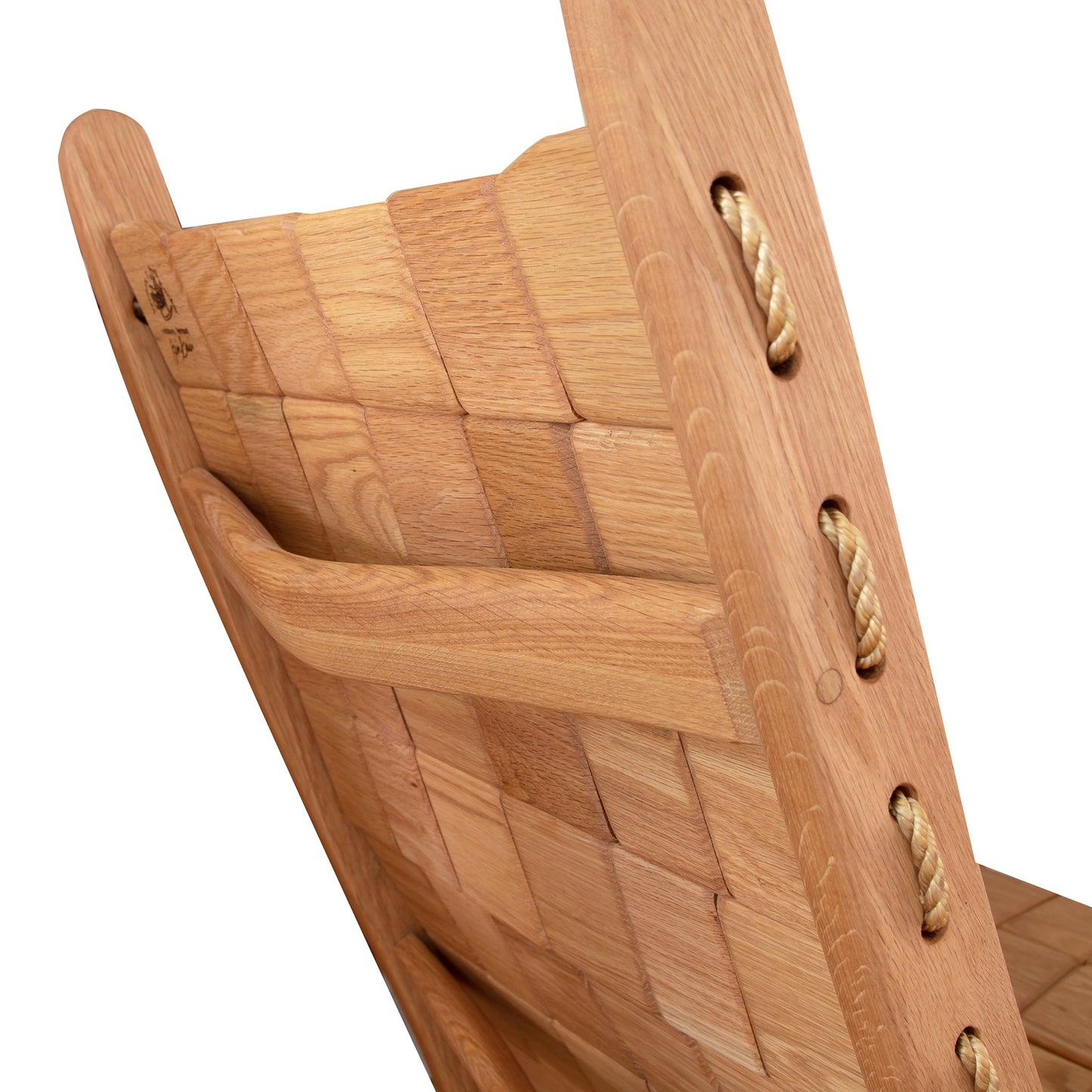 Close-up of a Vermont Folk Rocker Quilted Vermont Oak Rocking Chair showing detailed craftsmanship, with visible wood grains and rope joints. The focus is on the curved wooden slats and the secured rope ties.