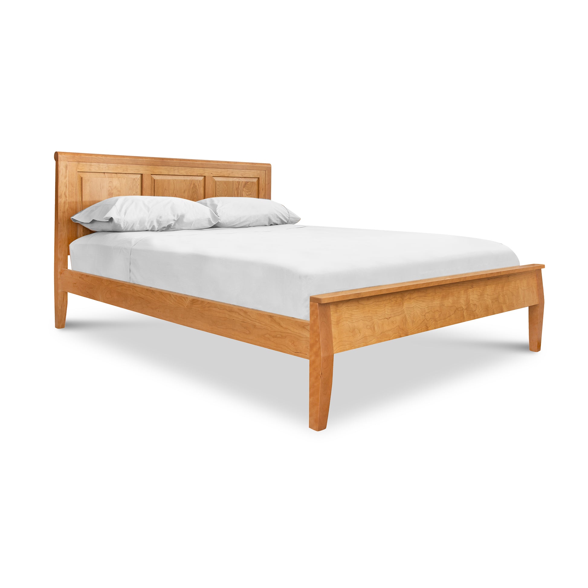 A solid hardwood Raised Panel Carriage Low Footboard Bed by Lyndon Furniture with comfortable white sheets on it.