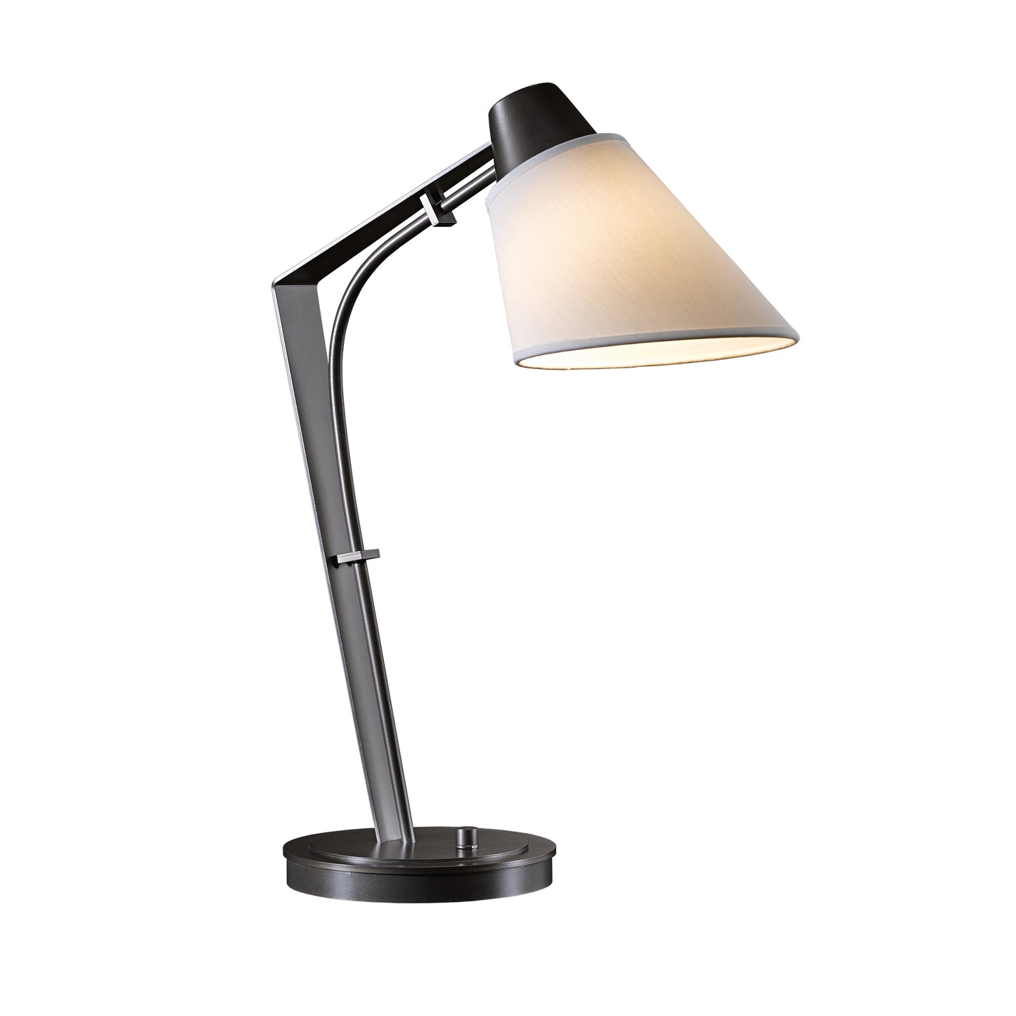 A Hubbardton Forge Reach Table Lamp with a hand-forged wrought iron base and adjustable arm, topped with a conical, light-colored lampshade, isolated on a white background.