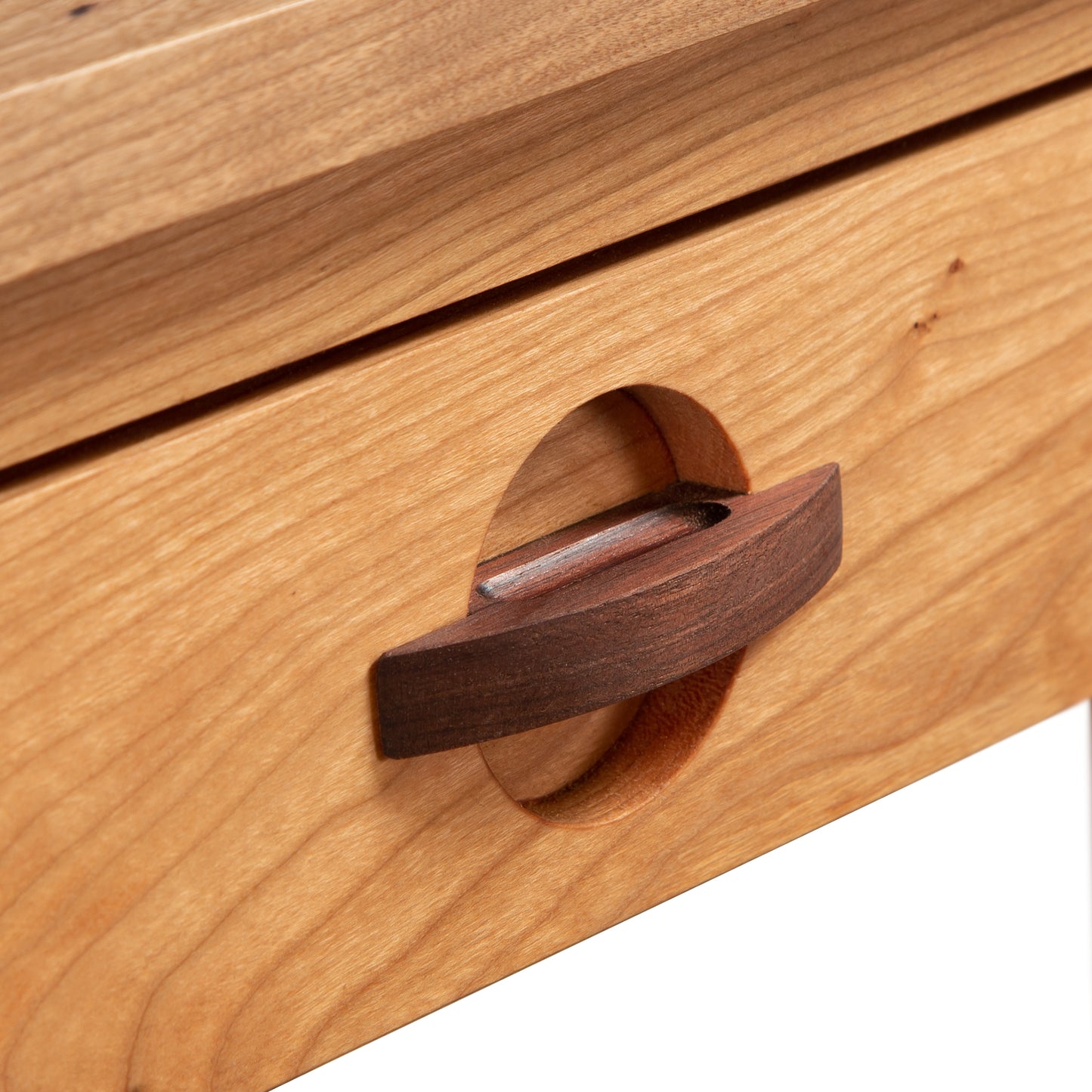 Handcrafted Ryegate Writing Desk by Maple Corner Woodworks with a unique wooden drawer featuring a circular cutout handle and contrasting darker brown pull, highlighting its solid wood craftsmanship.