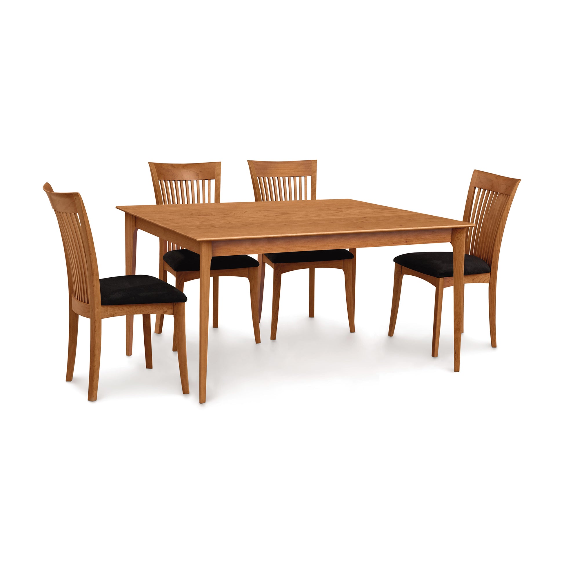 A handmade Copeland Furniture Sarah Shaker Tapered Leg Solid Top Table with four matching chairs set against a white background. The chairs have black cushioned seats, all part of the Sarah Shaker collection.