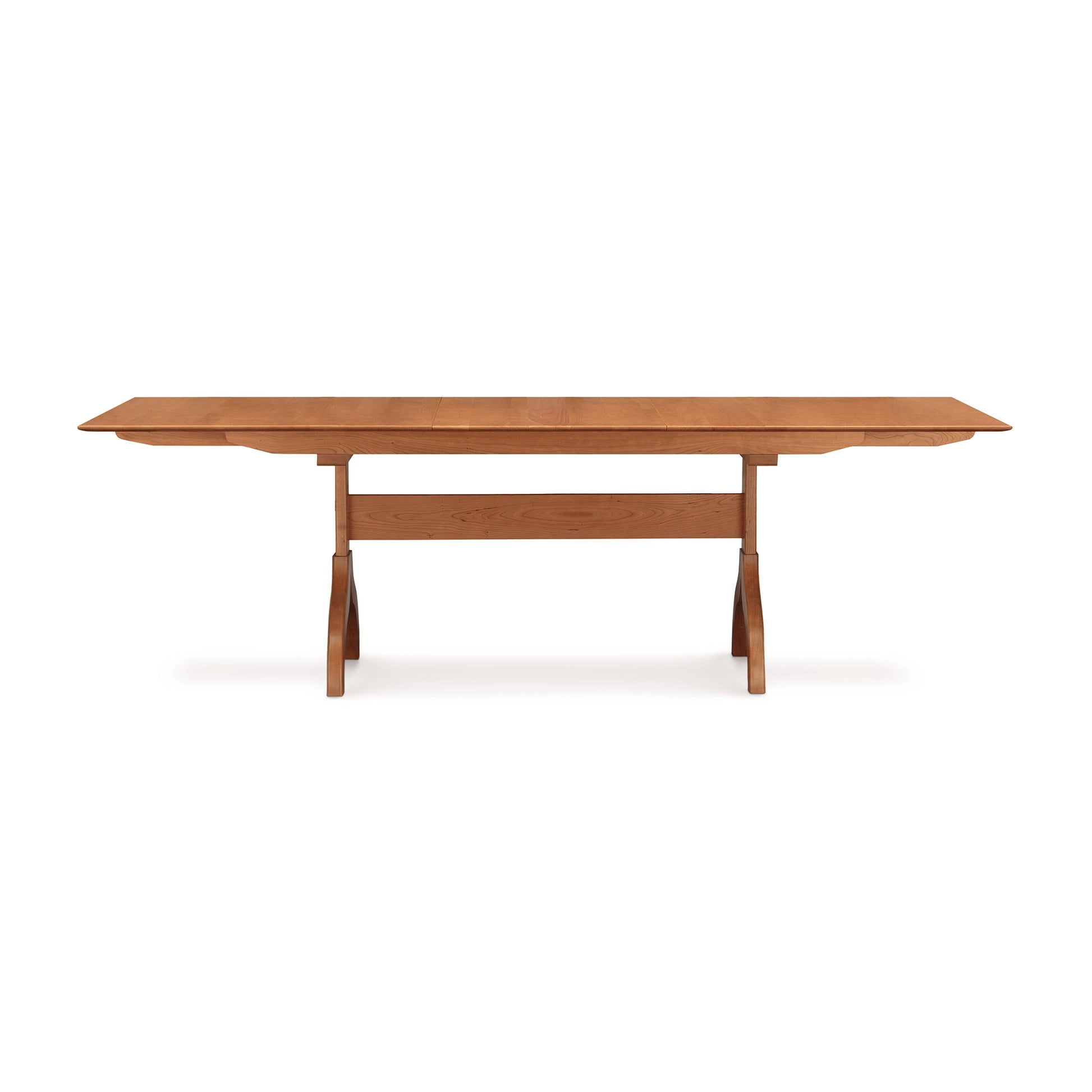 Sarah Shaker Collection cherry Copeland Furniture trestle-style extension dining table with extendable leaves on a plain background.