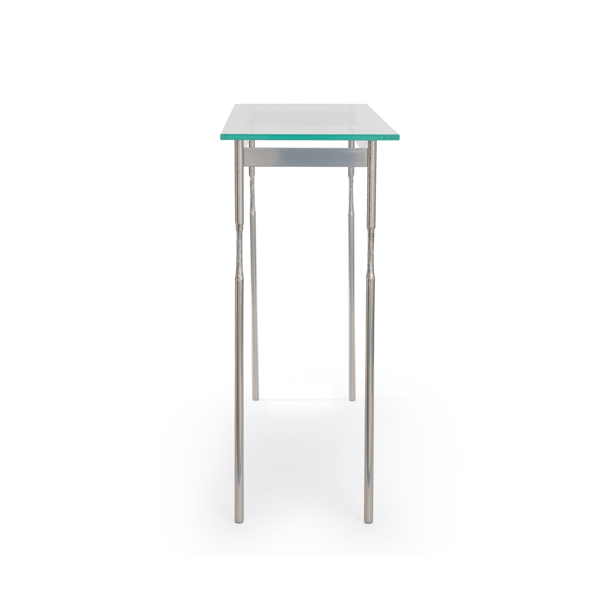 A Senza Console Table with metal legs and a tempered glass top by Hubbardton Forge.