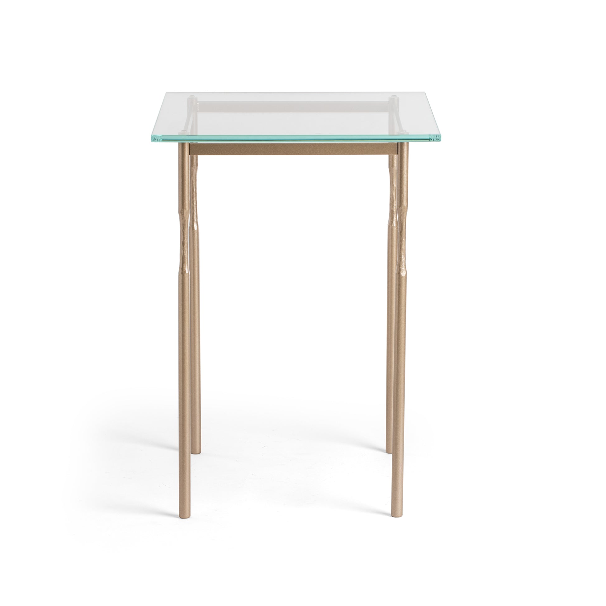 The Hubbardton Forge Senza Side Table is a modern home furniture piece featuring a glass top and elegant metal legs. It offers a sleek and contemporary look, making it perfect for any fine-tailored living.