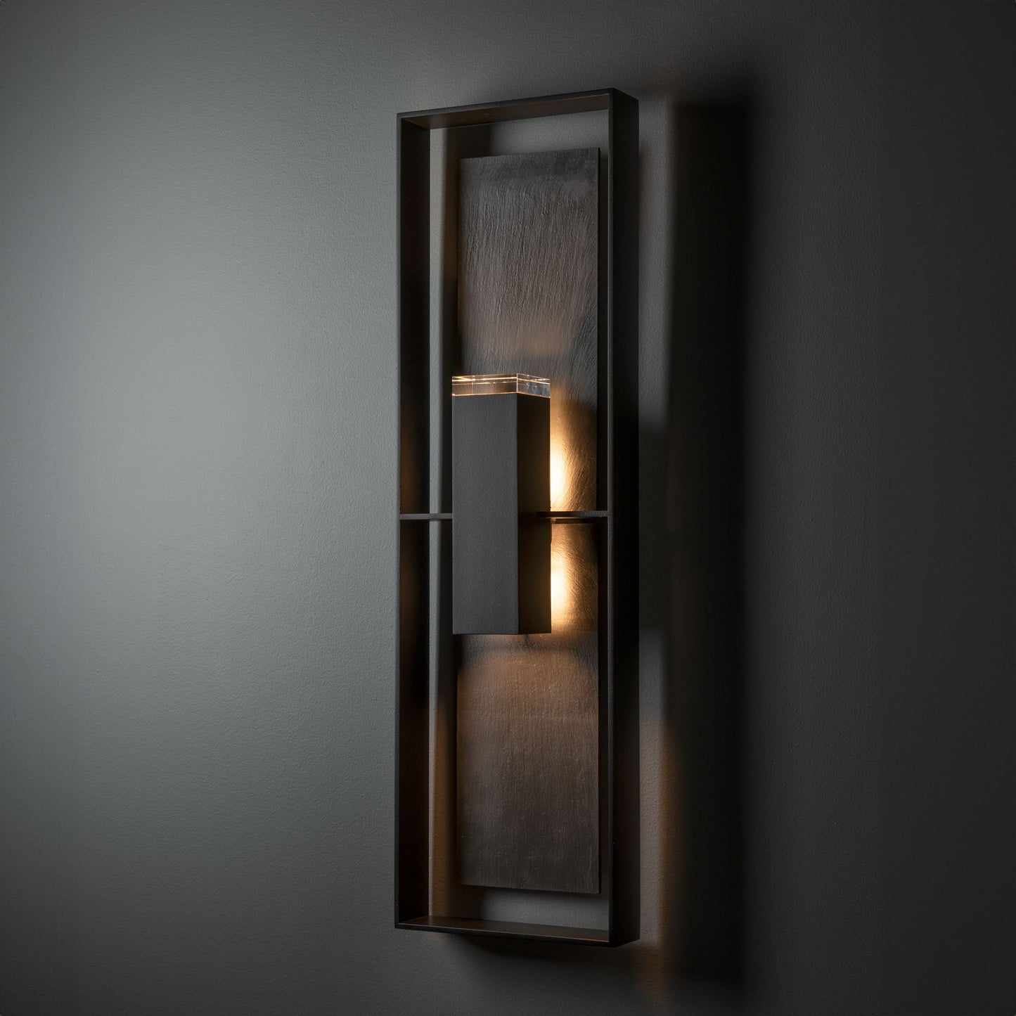 Shadow Box Tall Slate Dark Sky Sconce by Hubbardton Forge with dark metal frame, showcasing its modern design and soft illumination.