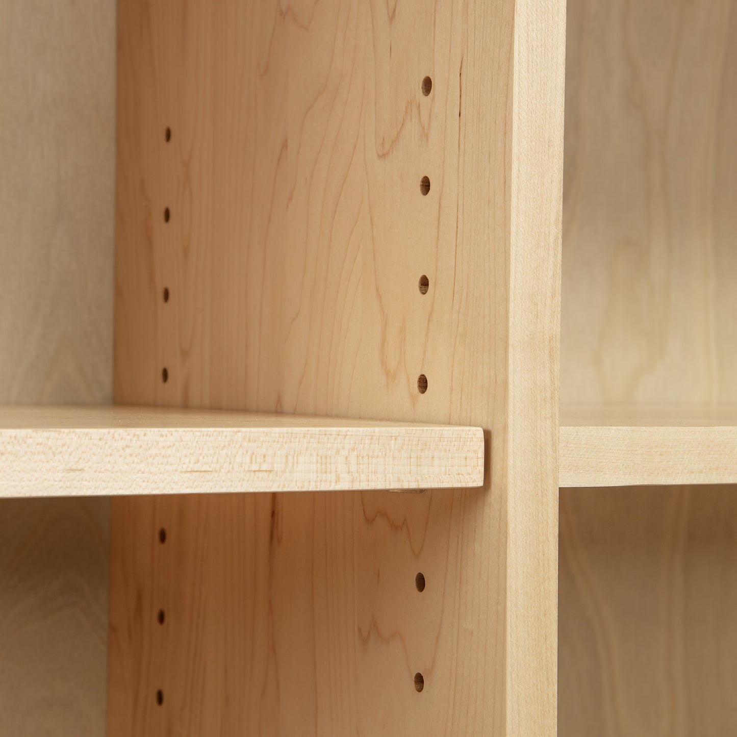 Shaker Wide Bookcase by Lyndon Furniture with light wood finish, adjustable pegs, and side slots for customizable shelf height.