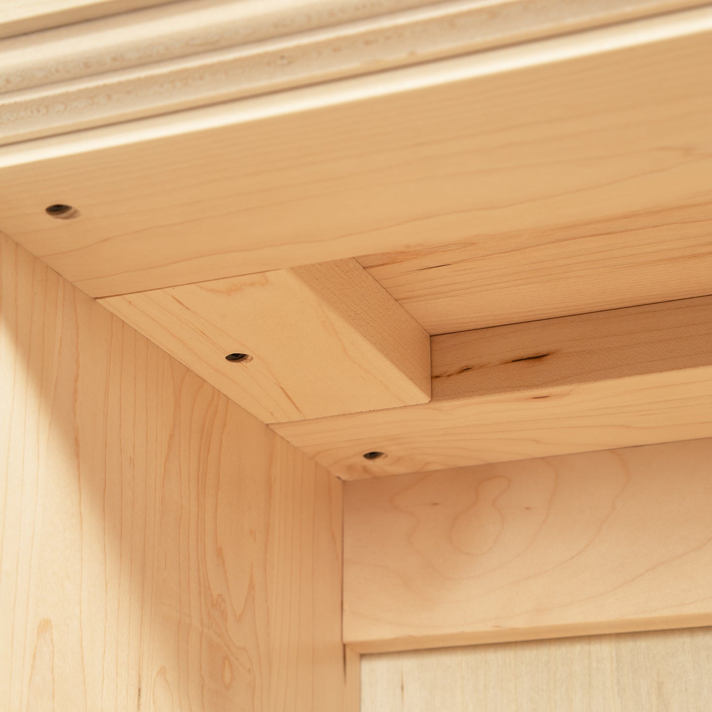 Shaker Wide Bookcase by Lyndon Furniture showcasing a precise corner joint with four screws and a refined light wood finish, highlighting its subtle grain pattern.