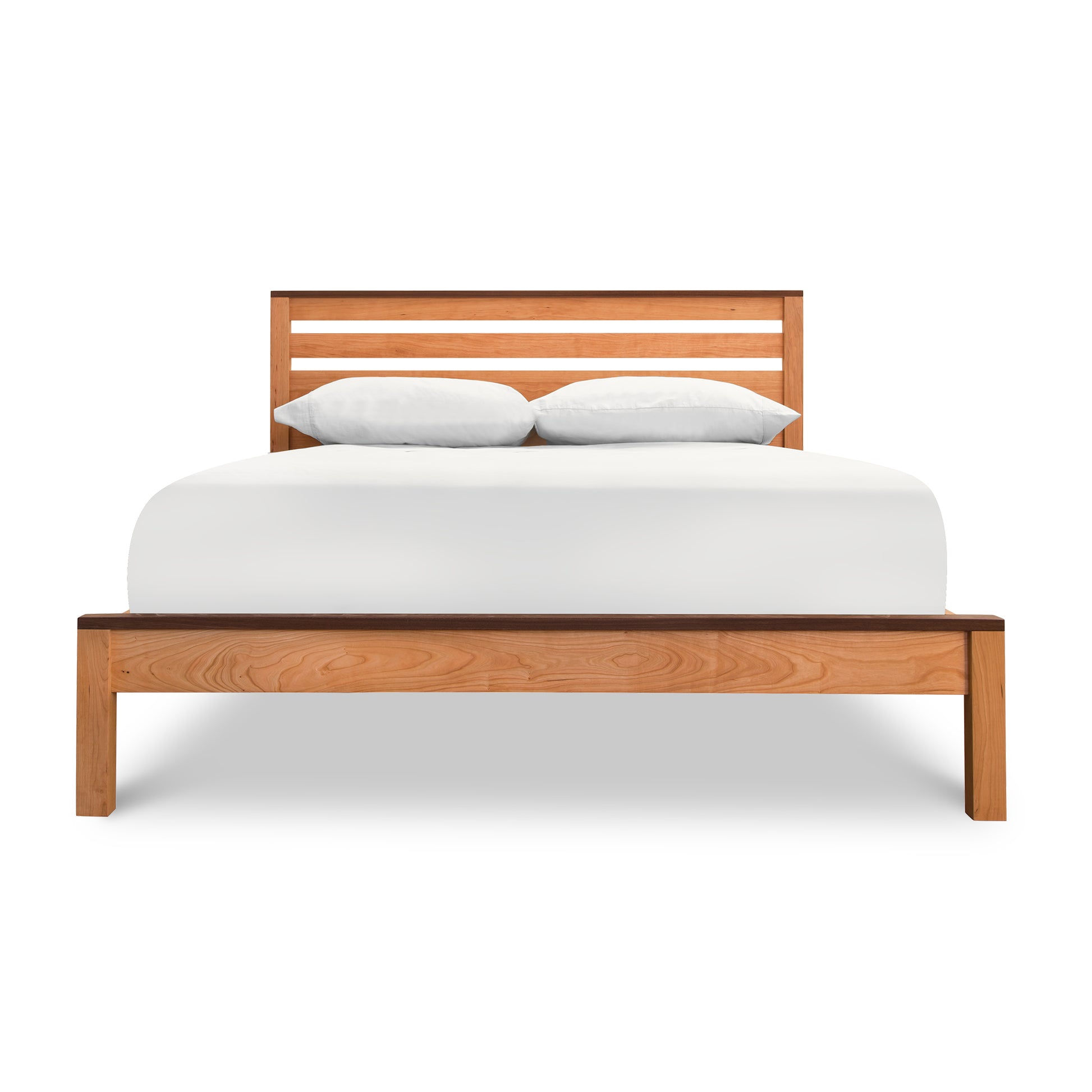 Skyline Panel Bed with a headboard, featuring a white mattress and two pillows, crafted from solid Cherry for an eco-friendly platform bed design by Vermont Furniture Designs.