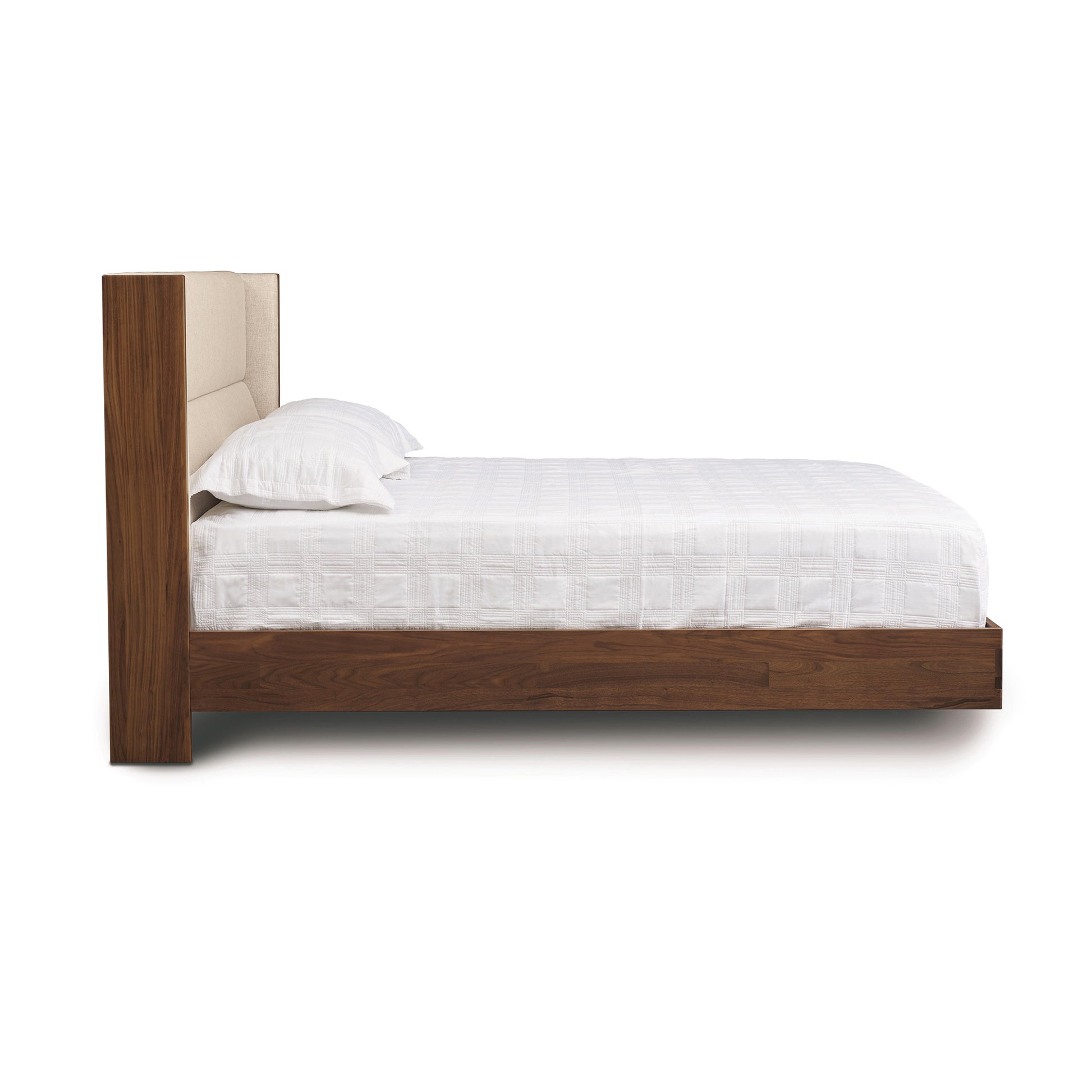Sloane Floating Bed by Copeland Furniture with tall upholstered headboard and white bedding, viewed from the side.