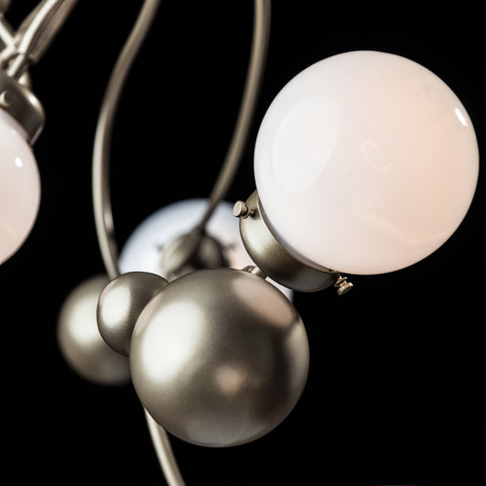 Hubbardton Forge Sprig Pendant with round white glass bulbs and metallic accents, showcasing its intricate craftsmanship.