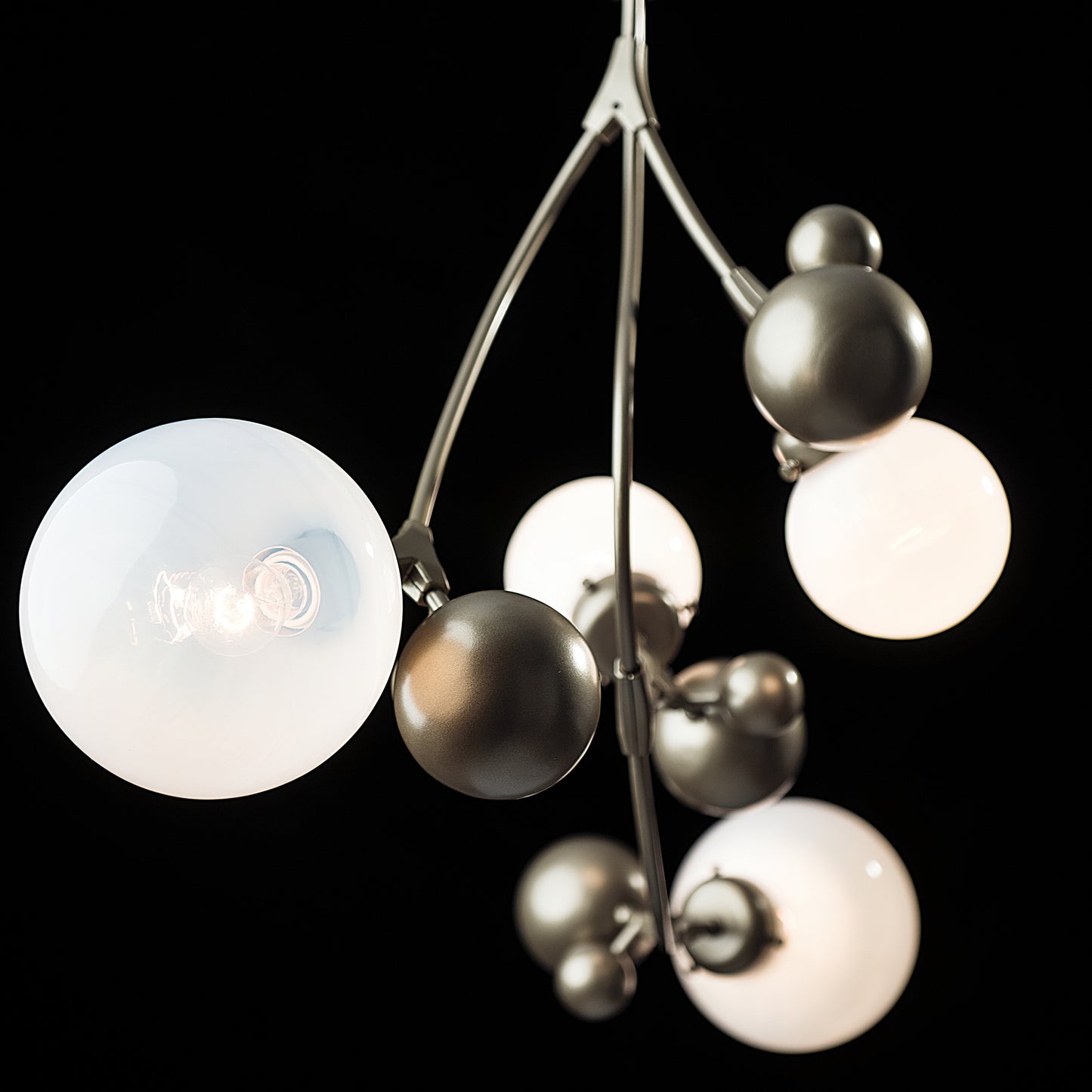 Sprig Pendant by Hubbardton Forge with spherical white glass and metallic shades, highlighting its elegant, modern design and craftsmanship.