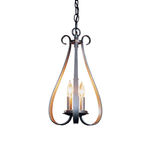 A Sweeping Taper 3-Arm Chandelier by Hubbardton Forge, with three candles hanging from it, showcasing a timeless style in a traditional design.