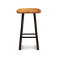 A Modern Farmhouse Tractor Counter Stool from Copeland Furniture with a tractor seat and black legs, isolated on a white background.
