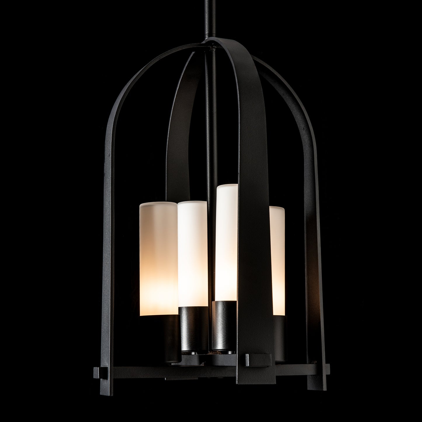 Triomphe Outdoor Lantern by Hubbardton Forge with four frosted glass shades in a Coastal Black caged frame, showcasing elegant craftsmanship.