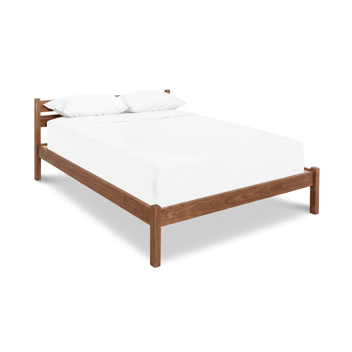 Vergennes Platform Bed from Vermont Furniture Designs, made of eco-friendly hardwoods, with white bedding and two pillows.