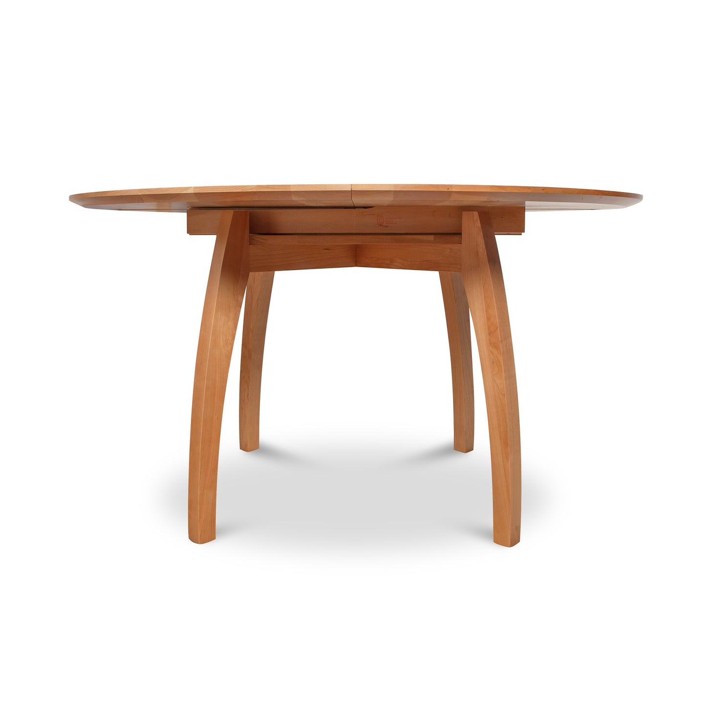 Vermont Modern Round Pedestal Extension Table, crafted from solid wood with a sleek surface and elegantly curved legs by Lyndon Furniture.