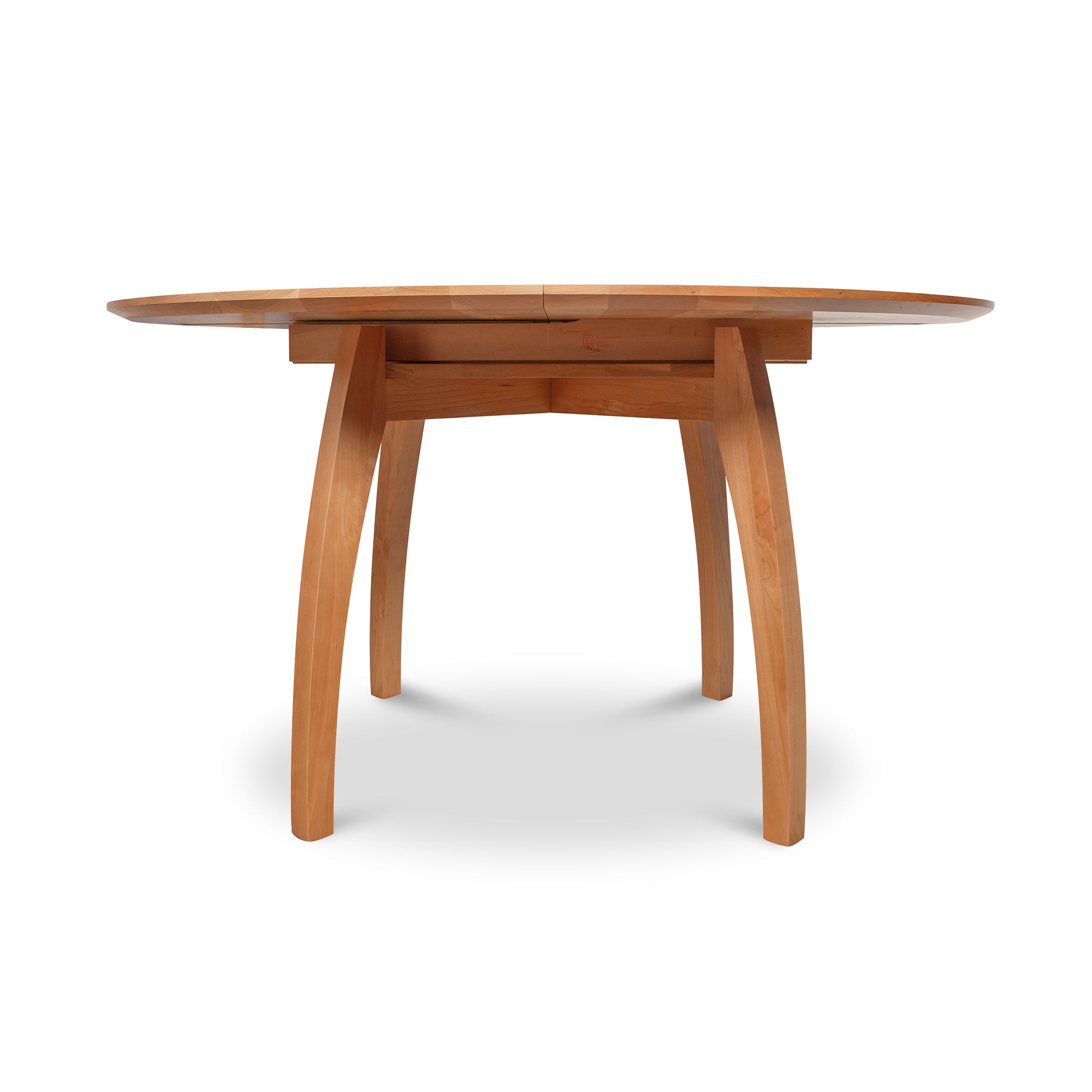 Vermont Modern Round Pedestal Extension Table, crafted from solid wood with a sleek surface and elegantly curved legs by Lyndon Furniture.