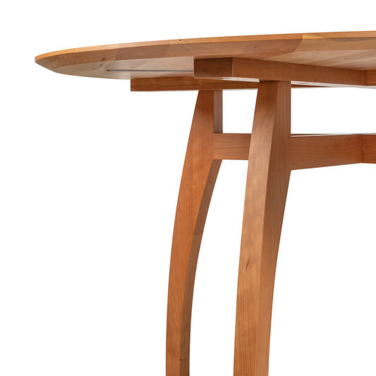 Vermont Modern Round Solid Top Pedestal Table by Lyndon Furniture, highlighting its curved legs and artisan-crafted solid wood construction.