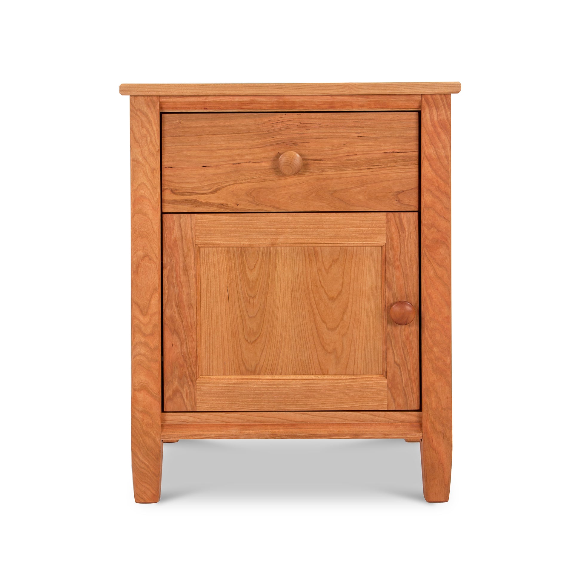 A Vermont Shaker 1-Drawer Nightstand with Door from Maple Corner Woodworks, featuring a natural cherry wood finish, one drawer, and a cabinet door, set against a plain white background.