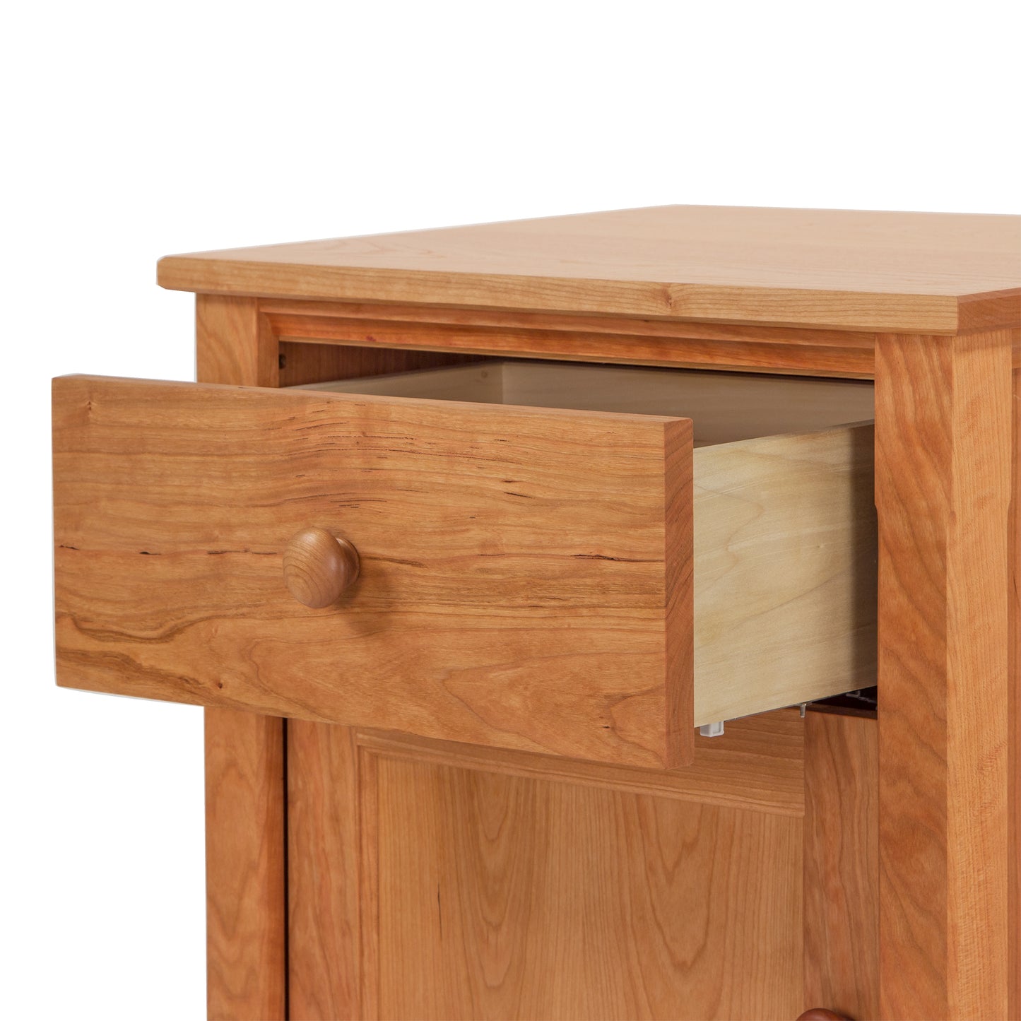 A Vermont Shaker 1-Drawer Nightstand with Door from Maple Corner Woodworks, crafted from eco-friendly materials and featuring a partially opened drawer revealing its light-colored interior, highlighting the natural wood grain and a simple round knob.