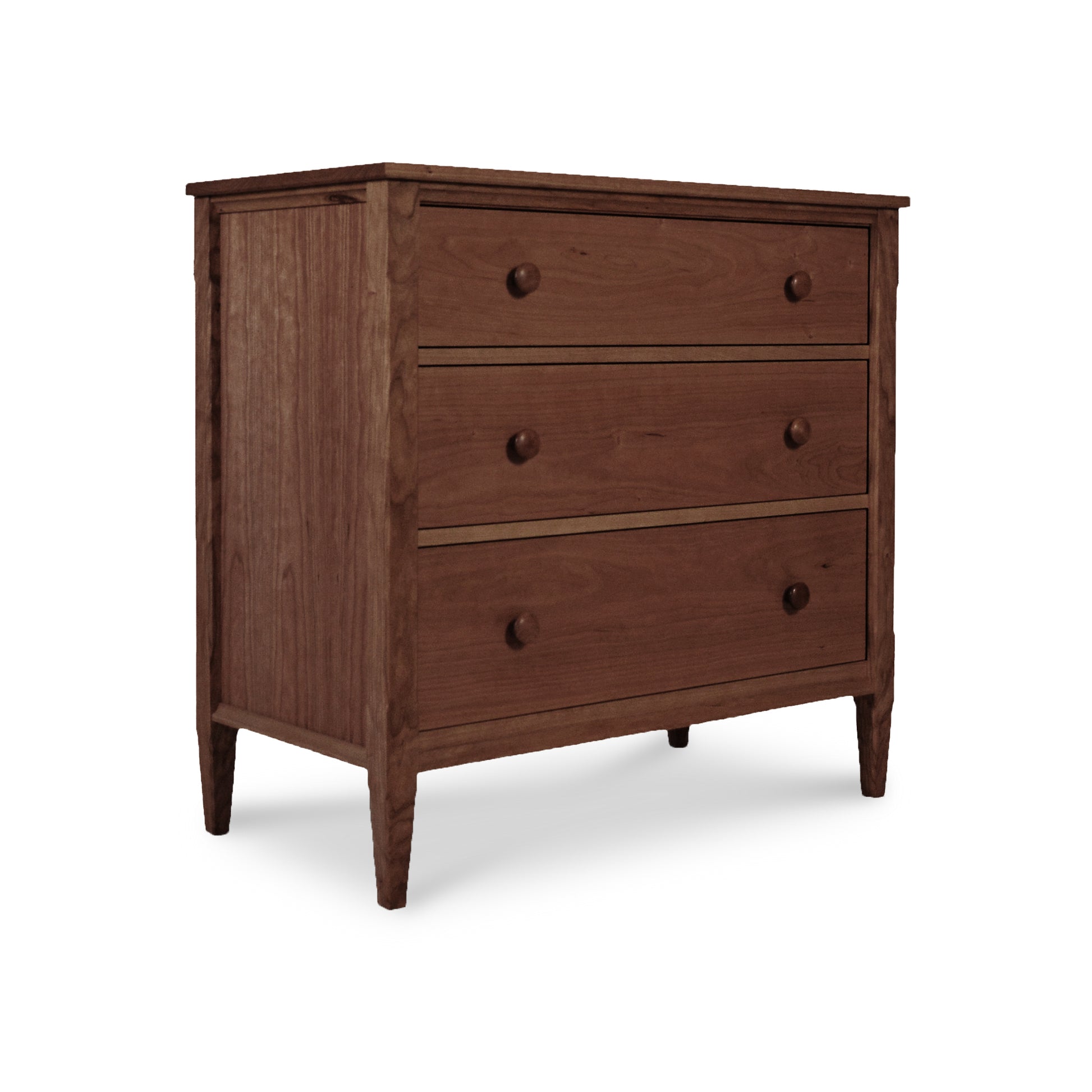 A Vermont Shaker 3-Drawer Chest by Maple Corner Woodworks, with a simple design and tapered legs, isolated on a white background.