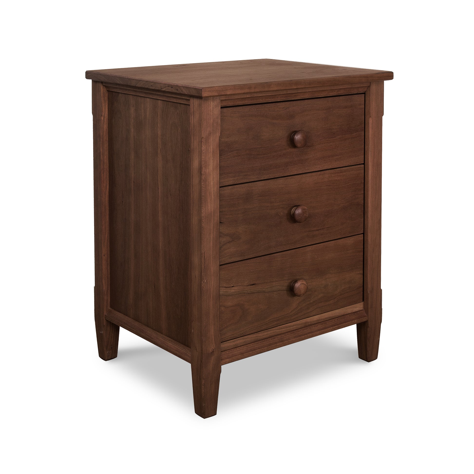 A Maple Corner Woodworks Vermont Shaker 3-Drawer Nightstand, crafted from eco-friendly natural hardwoods, features three drawers with round knobs and is isolated on a white background. This table has a simple, traditional design with a flat