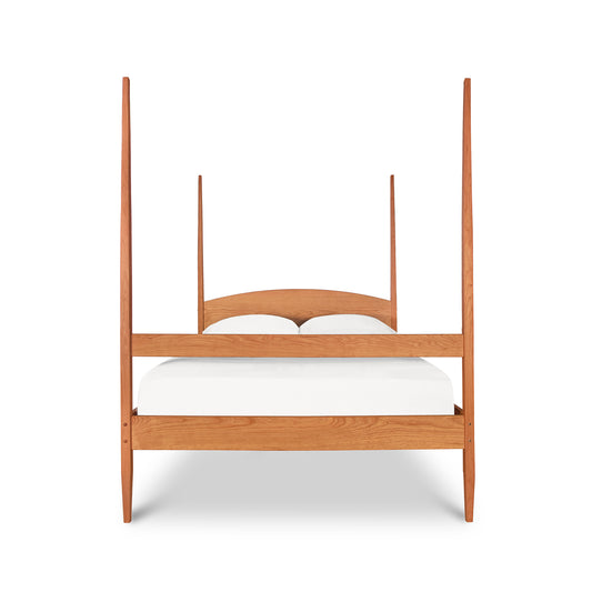 Vermont Shaker Four Poster Bed by Maple Corner Woodworks featuring a curved headboard and solid wood construction with a white mattress.