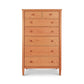 A tall hardwood dresser with seven drawers of varying sizes, crafted in the style of Maple Corner Woodworks, stands against a plain white background. Each drawer features round knobs and is made from natural cherry wood.