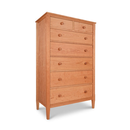 A Vermont Shaker 7-Drawer Chest, featuring seven stacked drawers with round knobs, standing on four tapered legs, isolated against a white background from Maple Corner Woodworks.