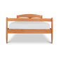 A simple Maple Corner Woodworks Vermont Shaker Bed frame with a curved headboard, underbed storage units, and a plain white mattress, isolated on a white background.