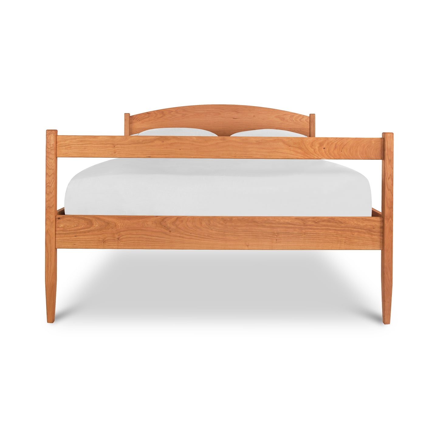 A simple Maple Corner Woodworks Vermont Shaker Bed frame with a curved headboard, underbed storage units, and a plain white mattress, isolated on a white background.