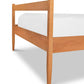 A Vermont Shaker Bed frame from Maple Corner Woodworks with a clean white mattress and underbed storage units, isolated on a white background, highlighting the smooth finish and minimalist design of the furniture.