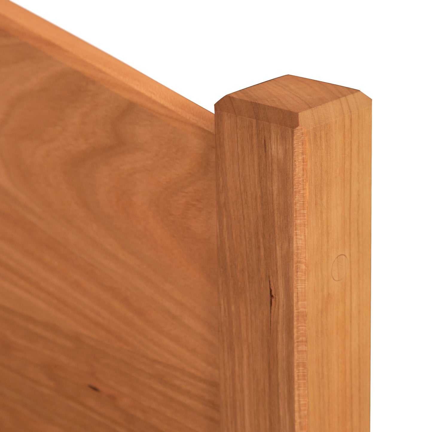 Close-up of the Vermont Shaker Bed frame by Maple Corner Woodworks, highlighting the detailed wood grain and sleek finish on the corner post and panel.