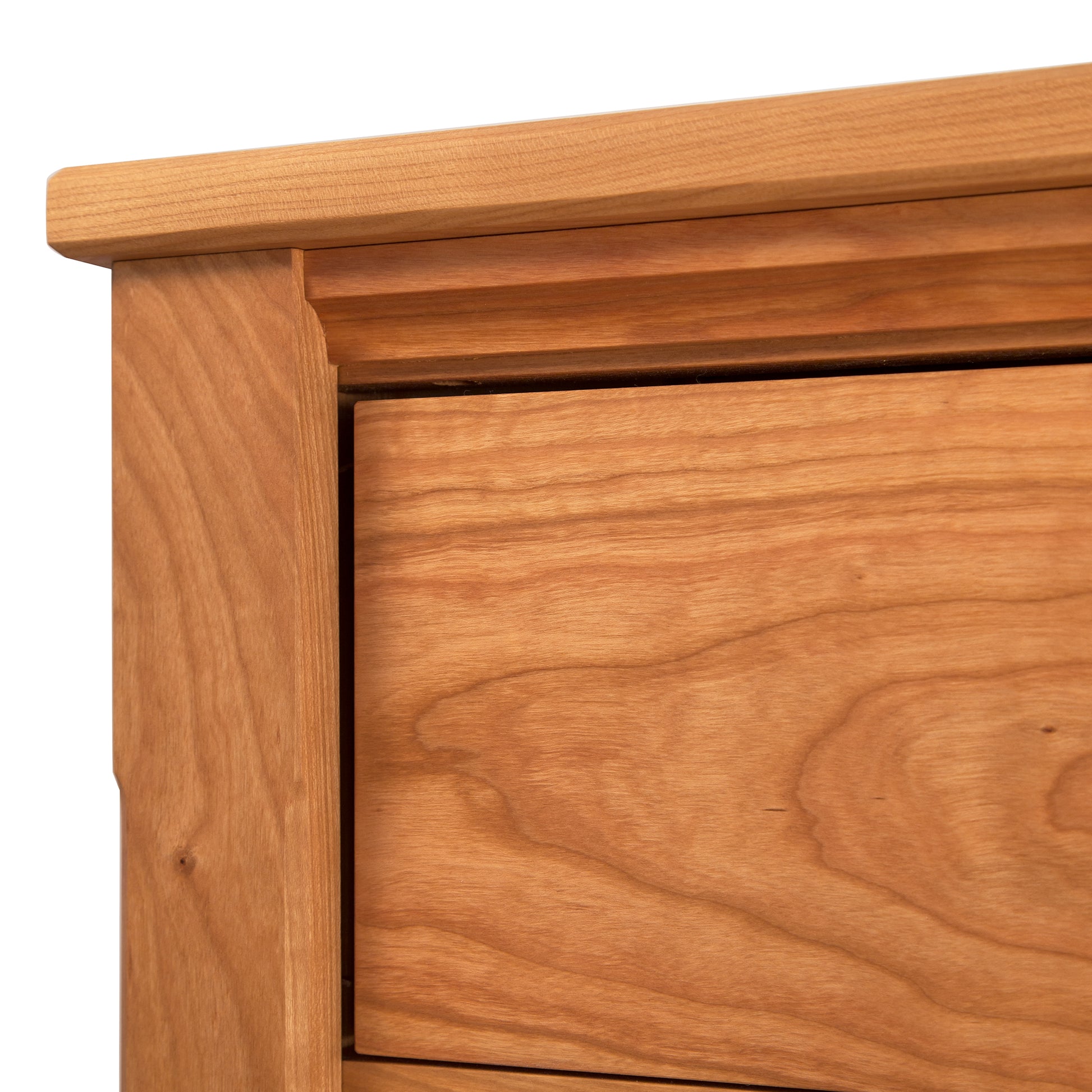 Close-up of a Maple Corner Woodworks Vermont Shaker Extra Wide Chest corner showing detailed wood grain texture and joinery craftsmanship on a light background.