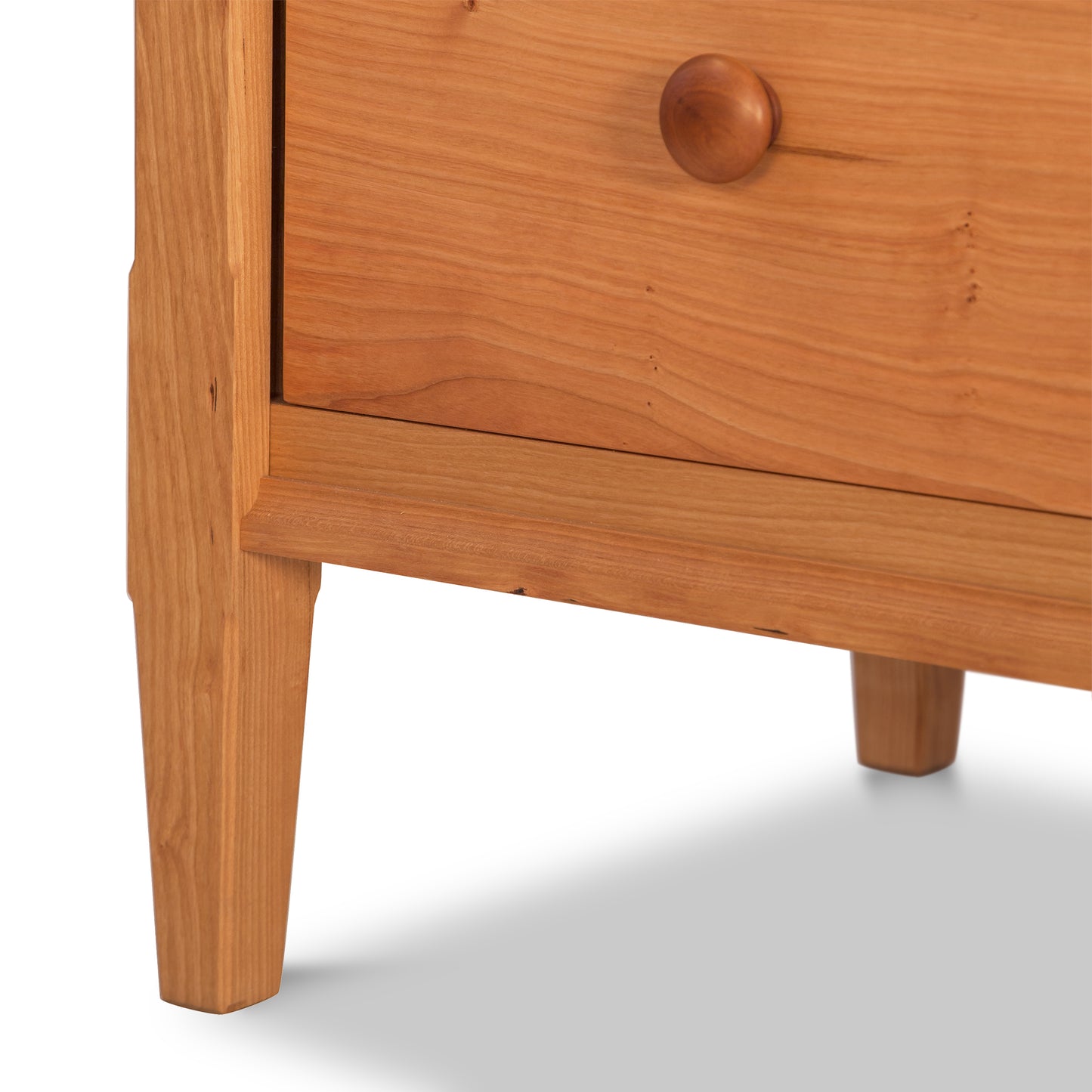 Vermont Shaker Extra Wide Chest dresser by Maple Corner Woodworks, highlighting a lower drawer with a round wooden knob and a light brown finish accentuating natural cherry tones.