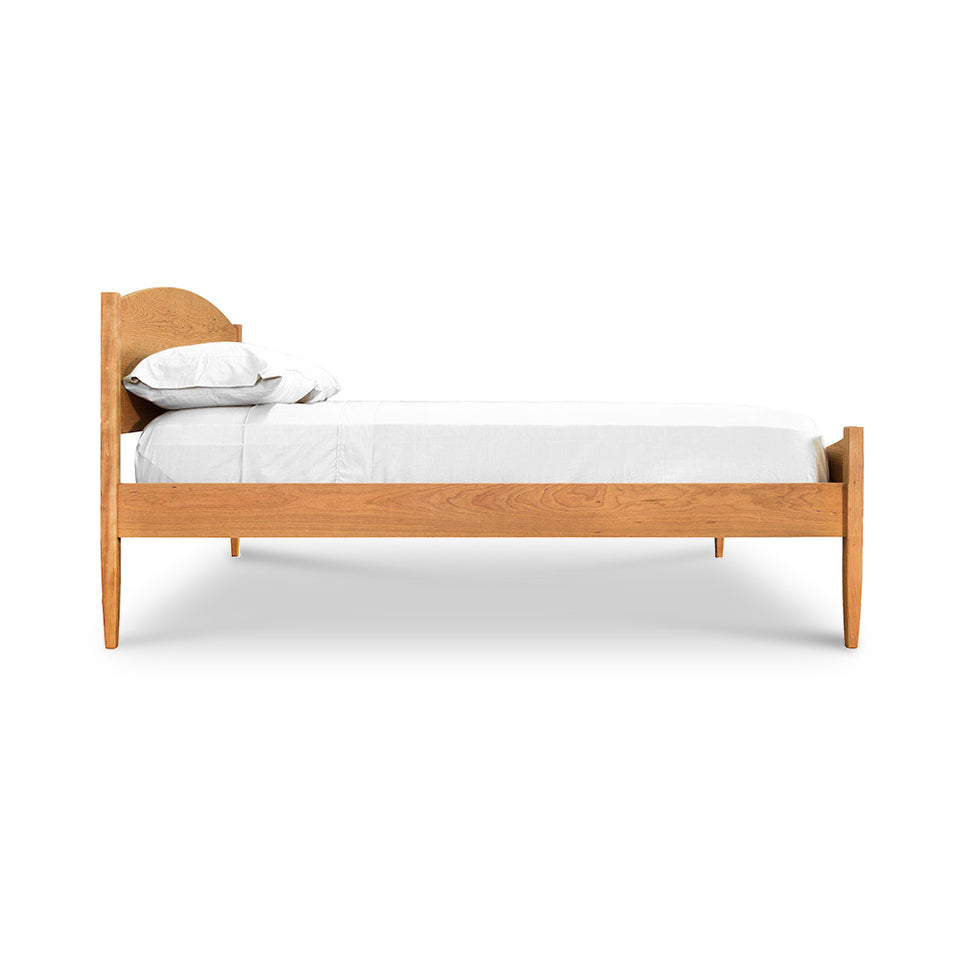 Vermont Shaker Moon Bed in side view with white mattress, pillows, and sheets; eco-friendly design by Maple Corner Woodworks in the Vermont Shaker Furniture Collection.