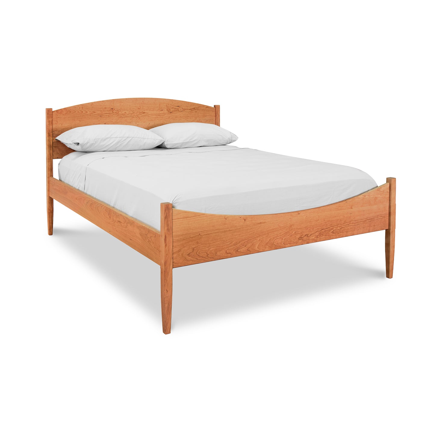 A Maple Corner Woodworks Vermont Shaker Moon Bed wooden platform bed frame with a mattress covered with white bedding and two pillows against a white background.