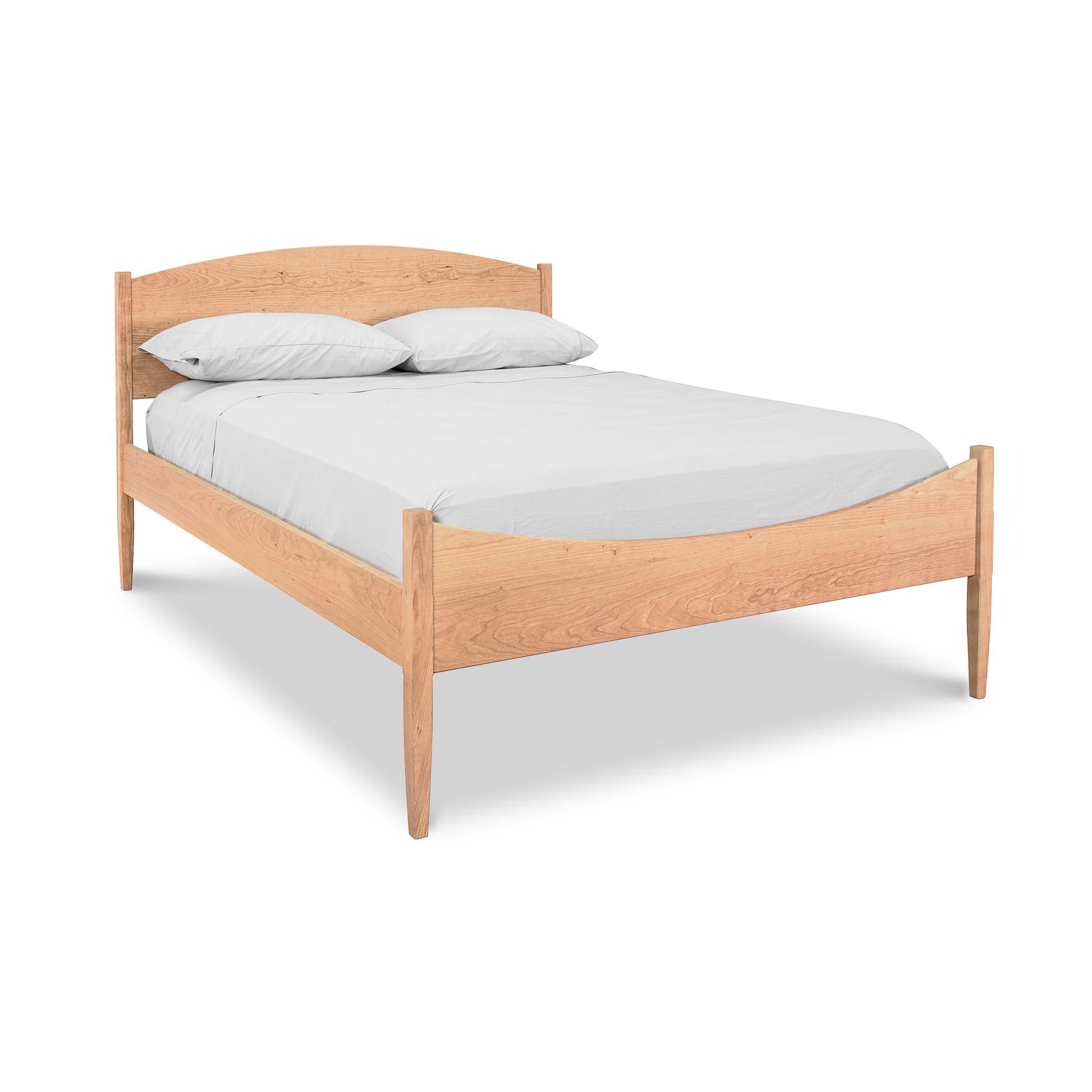 A Vermont Shaker Moon Bed frame with a mattress, two pillows, and white bedding from the Maple Corner Woodworks Collection, isolated on a white background.