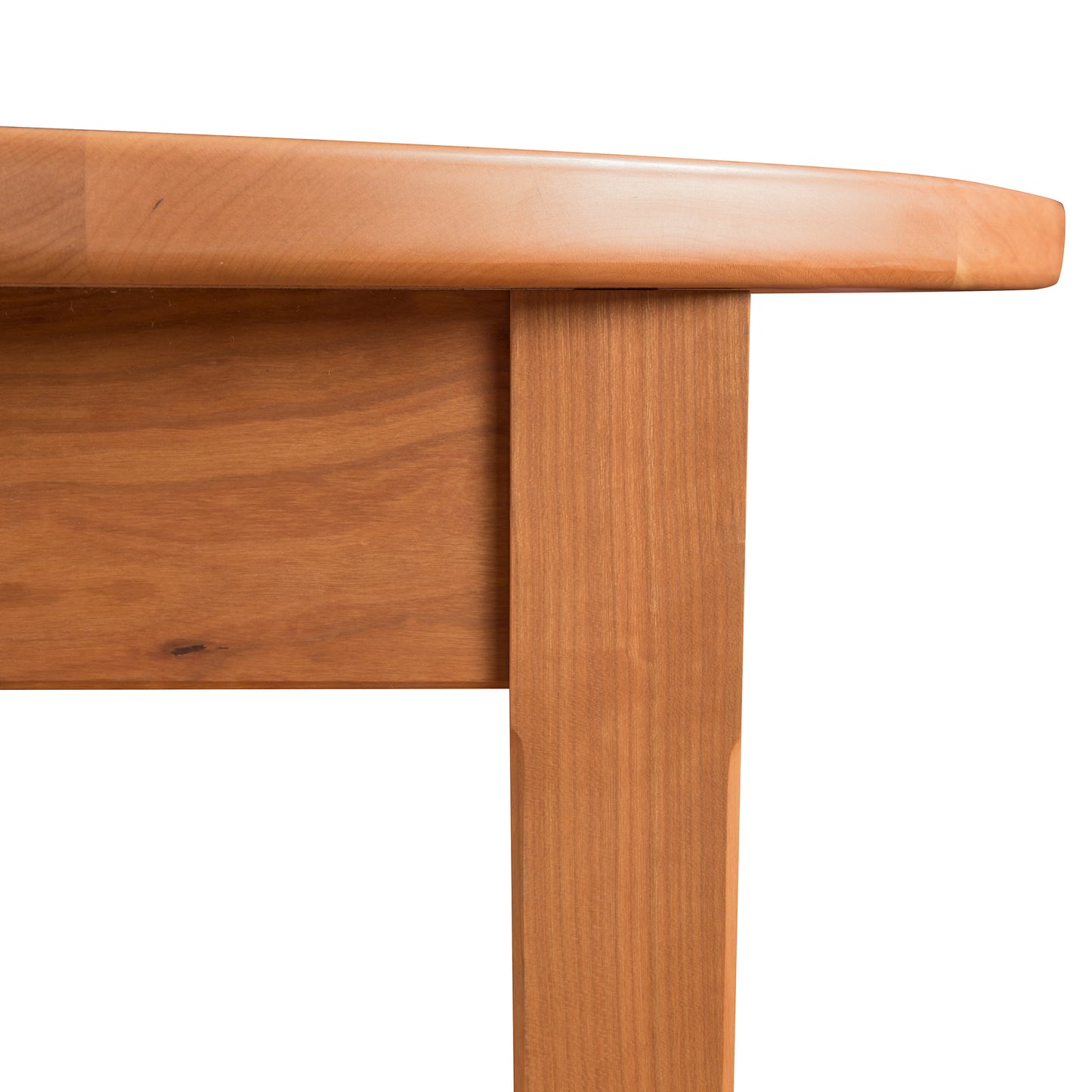 Vermont Shaker Oval Extension Dining Table by Maple Corner Woodworks, showcasing the smooth tabletop and one elegantly crafted leg with visible wood grain patterns. Made from sustainably harvested materials.