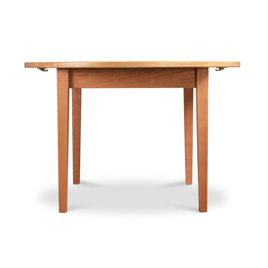 Vermont Shaker Round Extension Table by Maple Corner Woodworks, highlighting eco-friendly elegance.