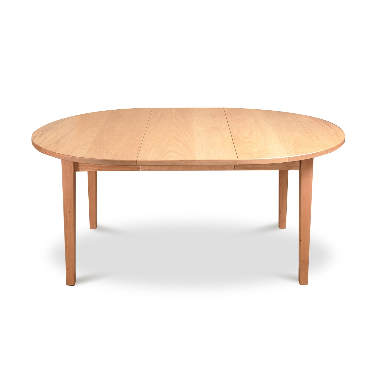 Vermont Shaker Round Extension Table by Maple Corner Woodworks, wooden dining table with natural finish, four legs and central seam for expansion.