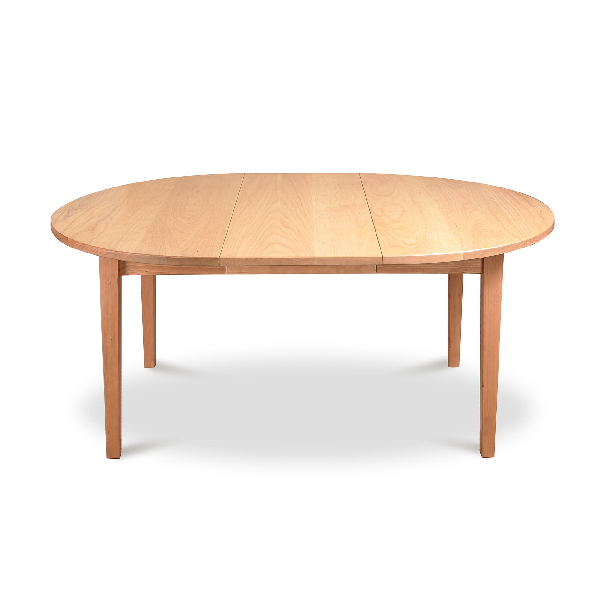 Vermont Shaker Round Extension Table by Maple Corner Woodworks, wooden dining table with natural finish, four legs and central seam for expansion.