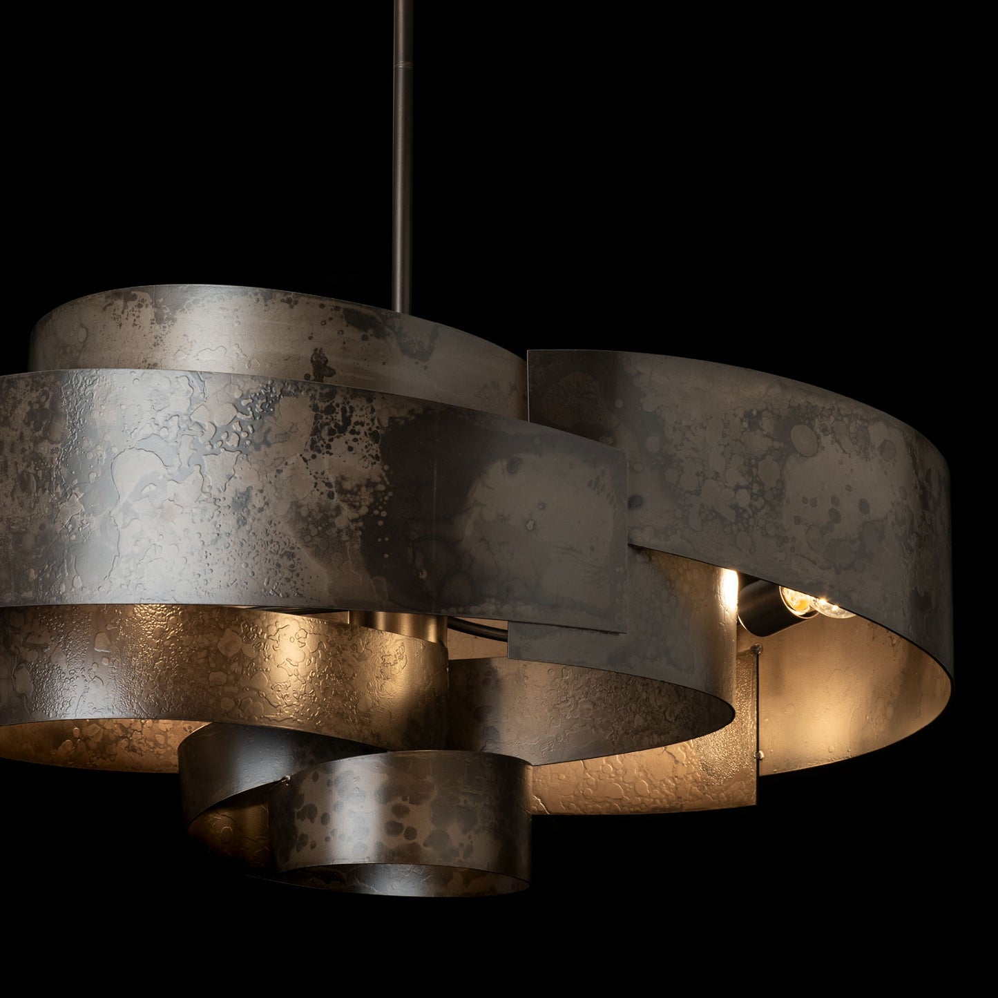 Zen Pendant light fixture with overlapping handcrafted metal bands in a dark matte finish, artisan-made by Hubbardton Forge.