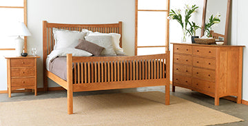 Stylish wooden bedroom set featuring a bed with a striped headboard, a nightstand with a lamp, and a dresser topped with a mirror.