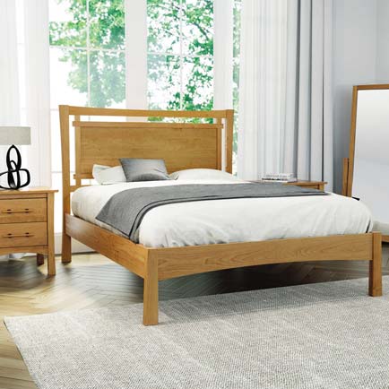 A bedroom with a wooden bed and dresser.