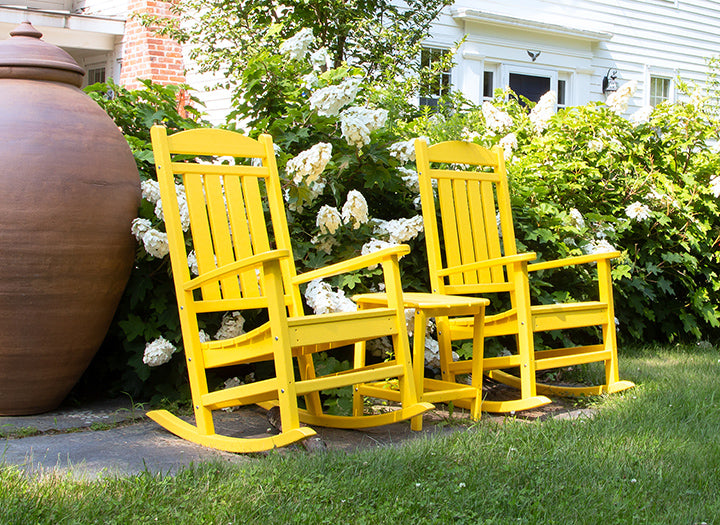 Yellow rocking chairs displayed prominently against a subtle garden backdrop.