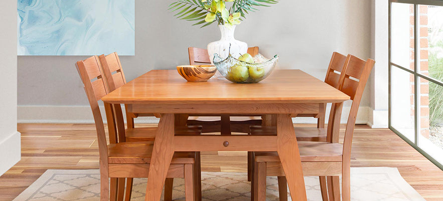 A wooden dining table and chairs in a room with a window.