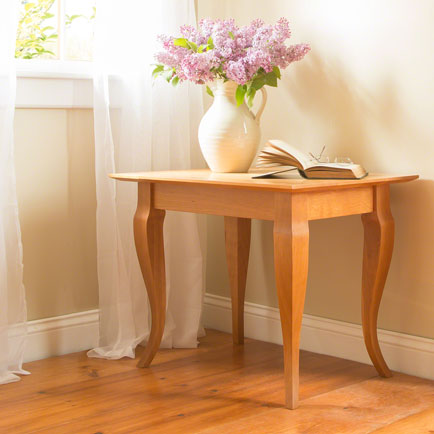 A wooden table with a vase of flowers.
