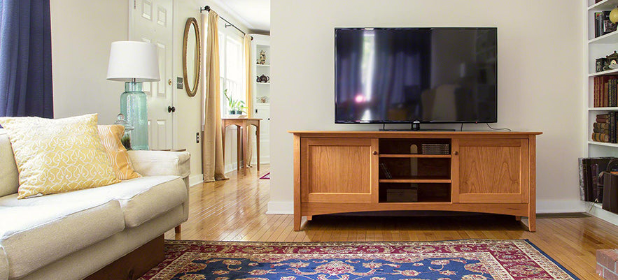 A living room with a tv and a rug.